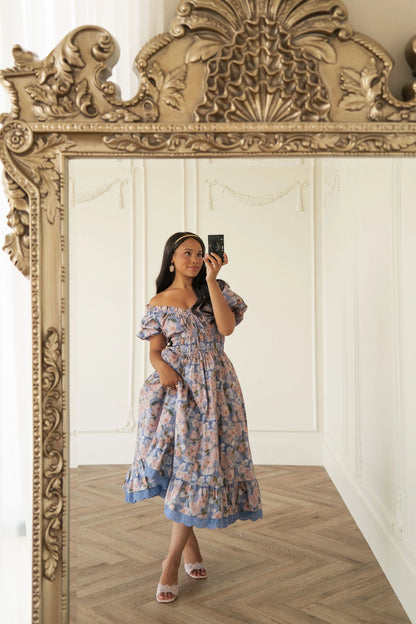 The image shows a woman taking a selfie in front of a mirror, wearing a beautiful blue and white floral dress. The dress is a size 6 and is perfect for a wedding, prom, or other special occasion. The